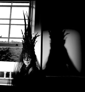Black & white photograph showing Jessica Wilcock wearing a headdress by Jay Briggs Millinery.