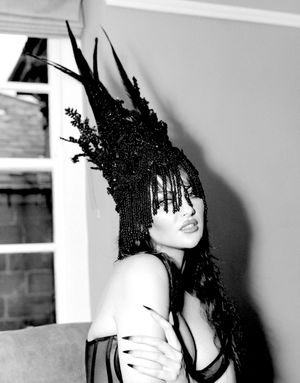 Black & white photograph showing Jessica Wilcock wearing a headdress by Jay Briggs Millinery. Corset by Perfect Corset New York City