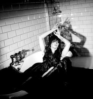 Black and white photograph showing Jessica Wilcock wearing a head dress by Jay Briggs Millinery