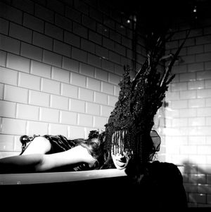 Black and white photograph showing Jessica Wilcock wearing an head dress by Jay Briggs Millinery