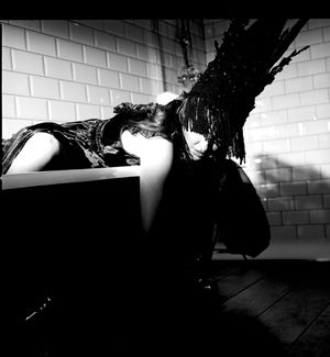 Black and white photograph showing Jessica Wilcock wearing a head dress by Jay Briggs Millinery