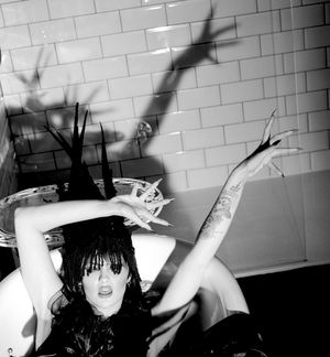 Black and white photograph showing Jessica Wilcock wearing a head dress by Jay Briggs Millinery