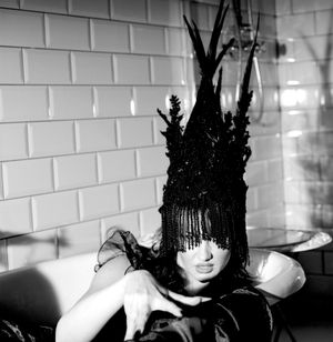 Black and white photograph showing Jessica Wilcock wearing a head dress by Jay Briggs Millinery