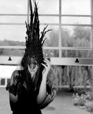 Black and white photograph showing Jessica Wilcock wearing a head dress by Jay Briggs Millinery