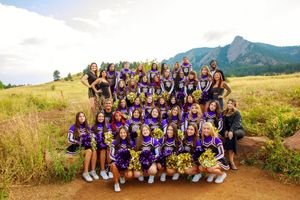 Group photos of cheerleaders posing together on mountainous hillsides wearing purple and white uniforms.