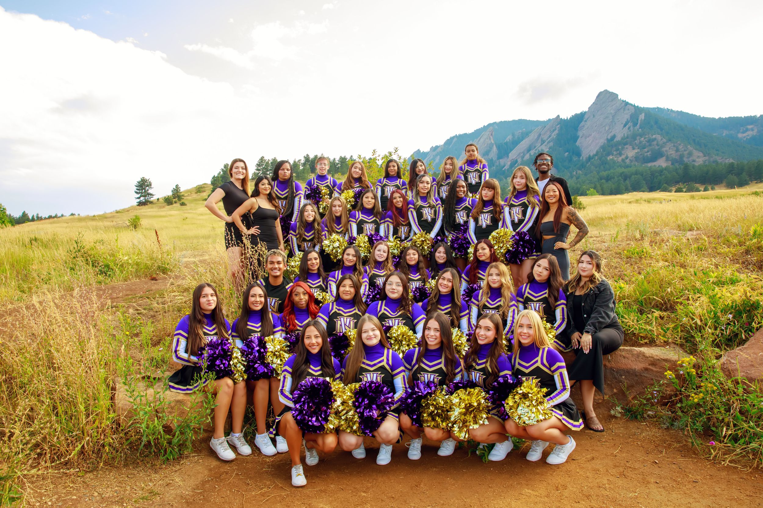 Group photos of cheerleaders posing together on mountainous hillsides wearing purple and white uniforms.