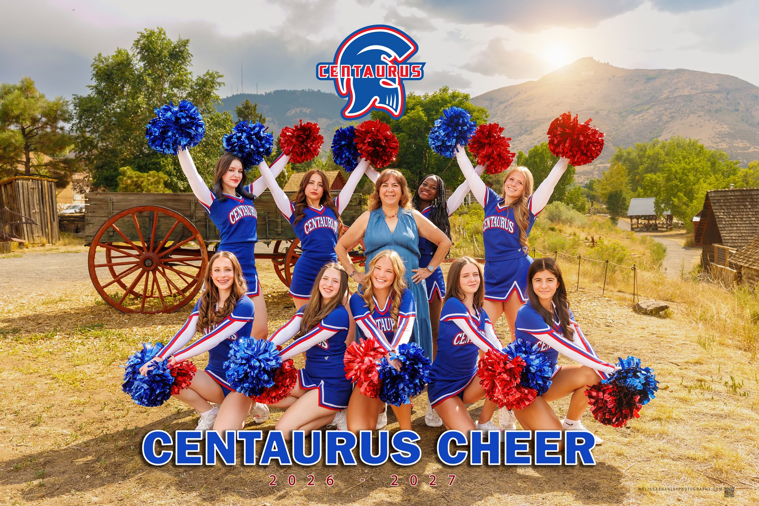 Centaurus Cheer squad poses in blue uniforms with red and blue pom-poms outdoors with mountains in background.