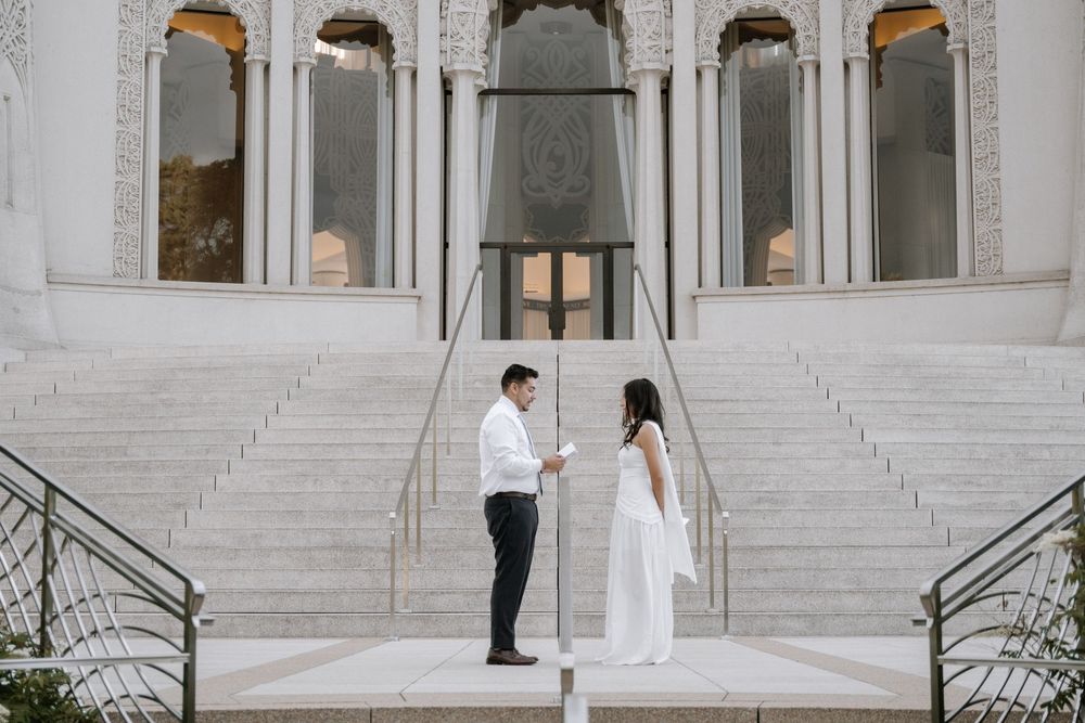 White marble steps and arched entranceway of the Baha'i Temple with ornate architectural details.