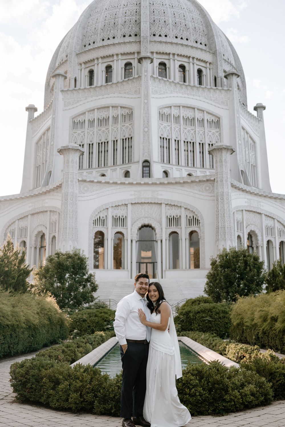 Ornate white domed Baha'i Temple in Chicago with manicured gardens and architectural details.
