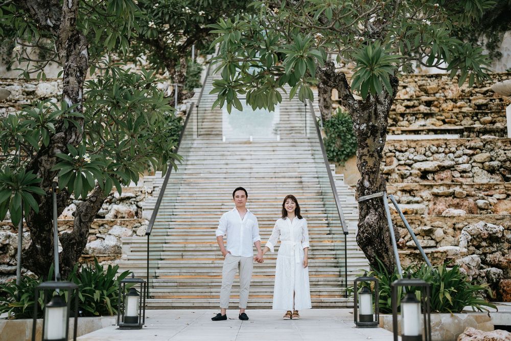 Garden stairway scene with lanterns and greenery as couple walks down stone steps.