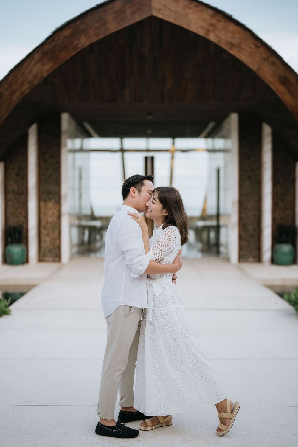 Romantic moment captured inside an architectural arch-shaped structure.