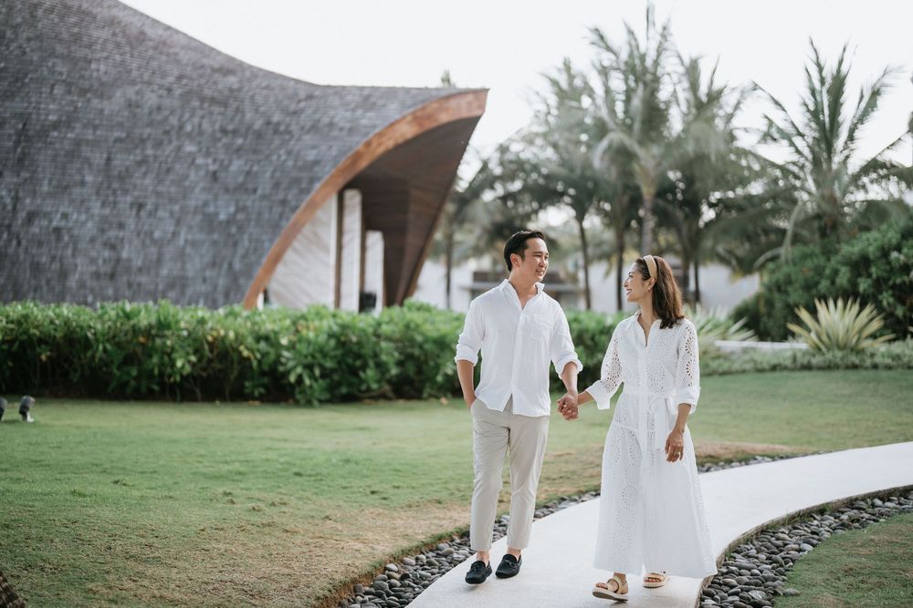 Couple strolling on pathway with modern chapel architecture in background.