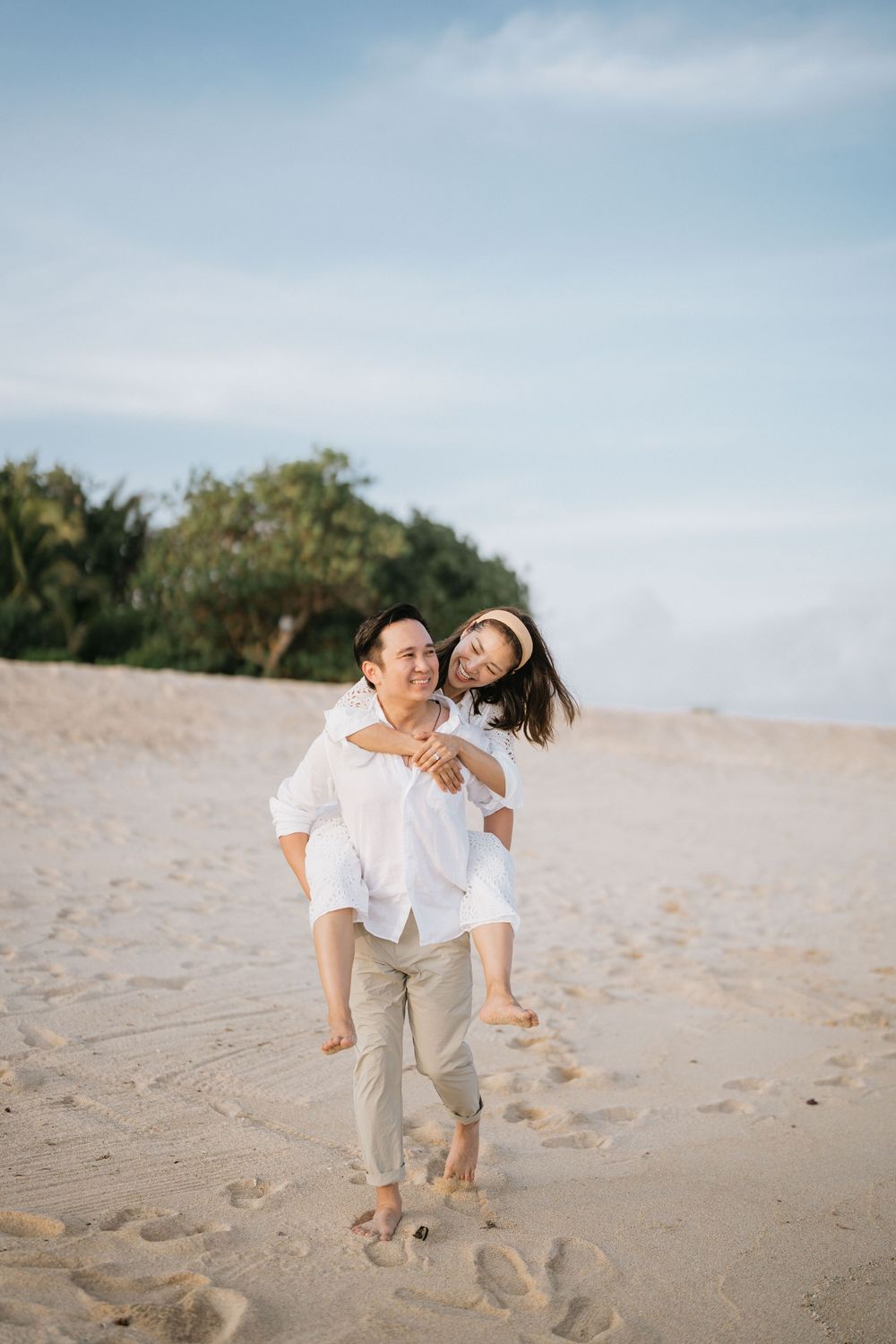 Couple sharing a romantic moment while running on the beach sand.
