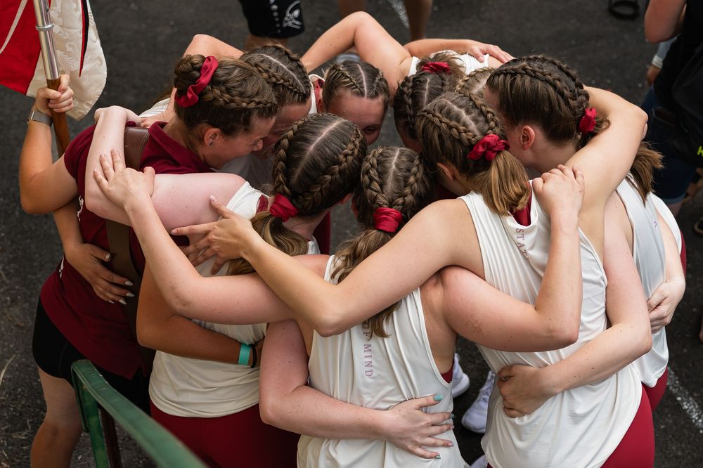 Dancers in an intimate embrace perform close steps during a social dance gathering on a crowded dance floor.