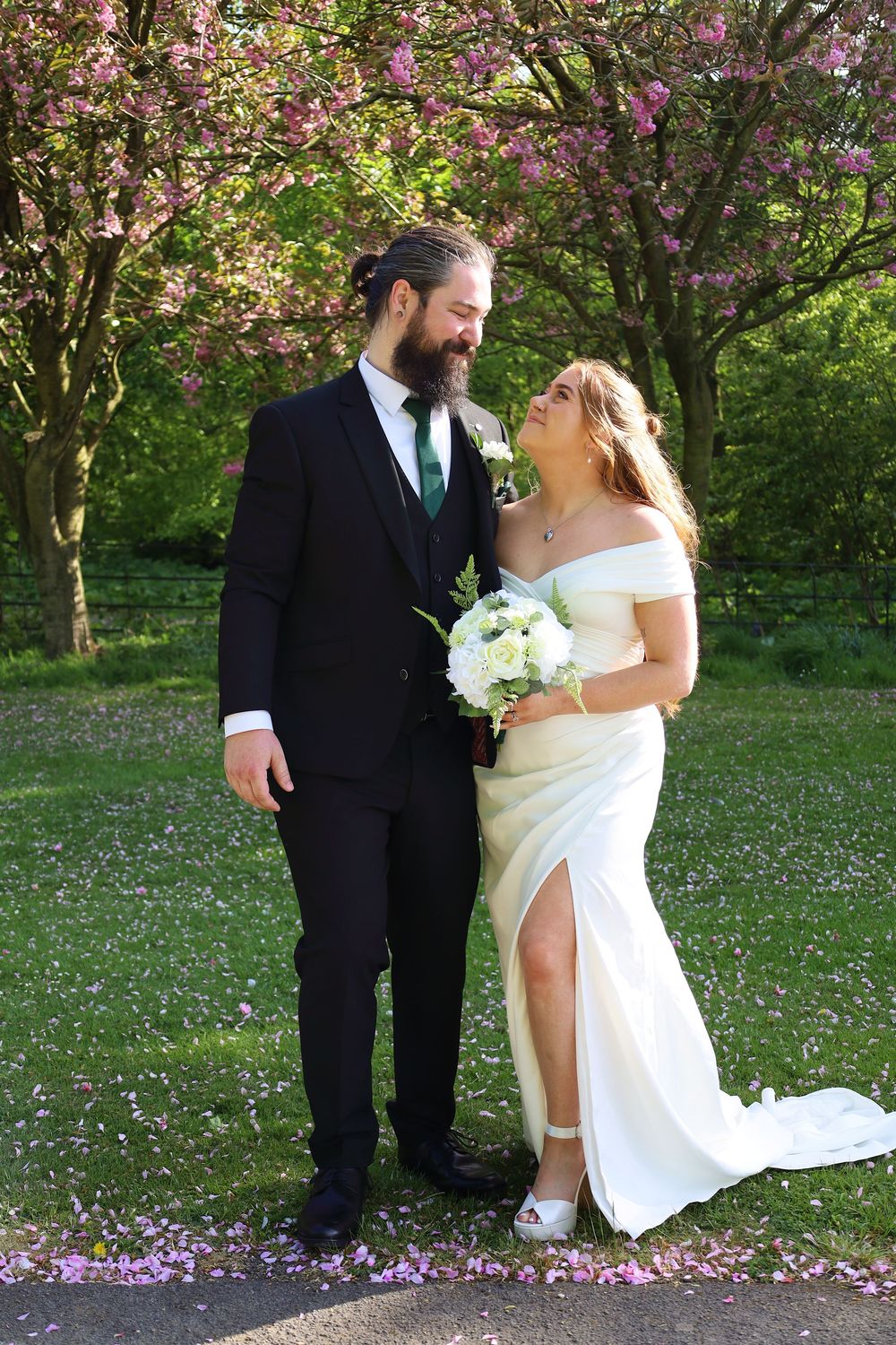 A springtime wedding photo with blooming cherry blossoms creating a romantic backdrop.
