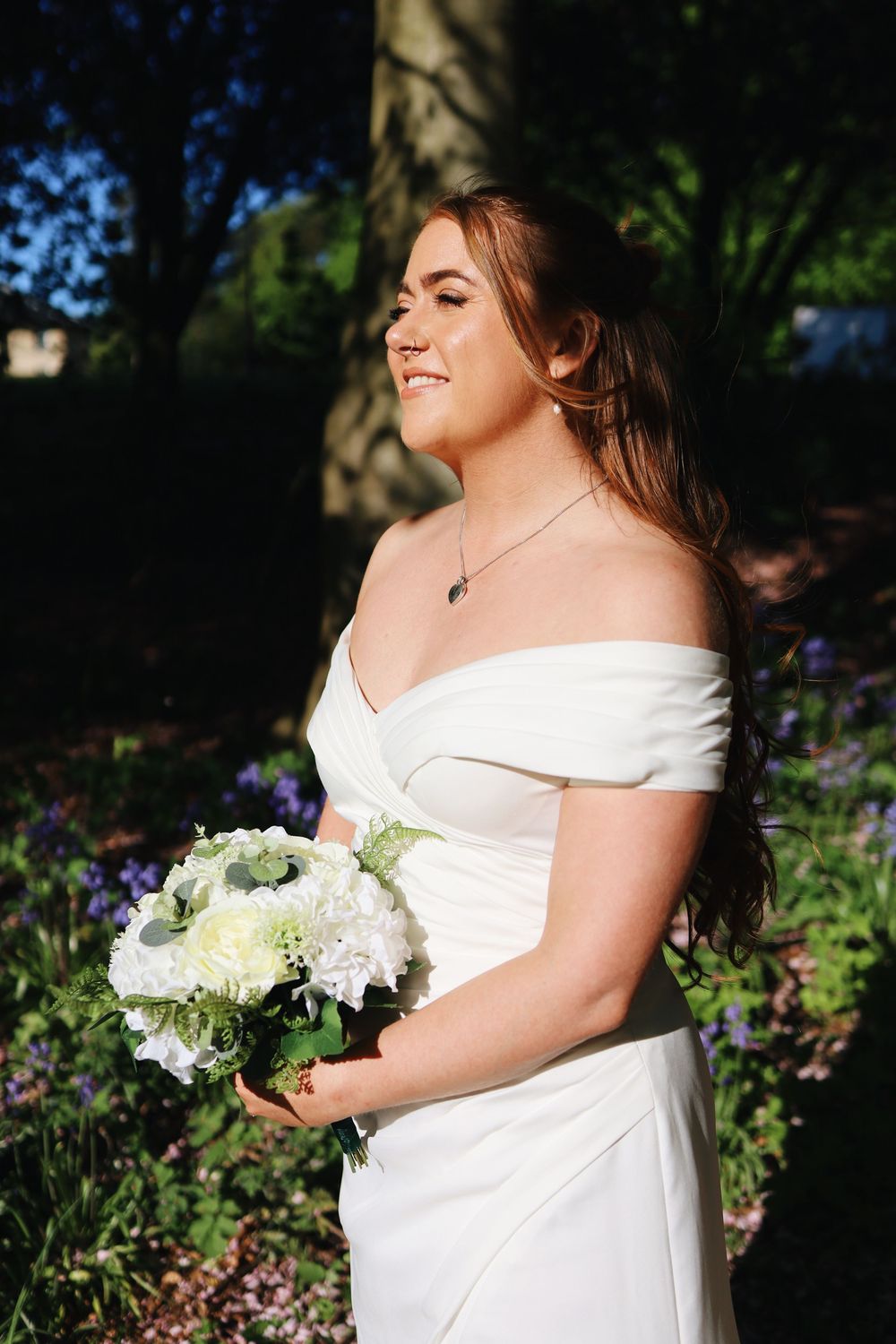 Beautiful bridal portraits in an outdoor garden setting with white floral bouquet.