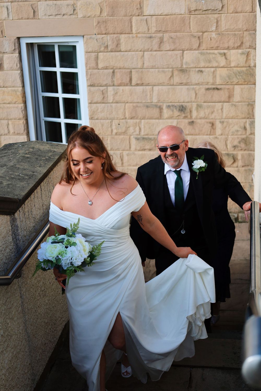 Two people ascending stone steps together during a wedding ceremony.