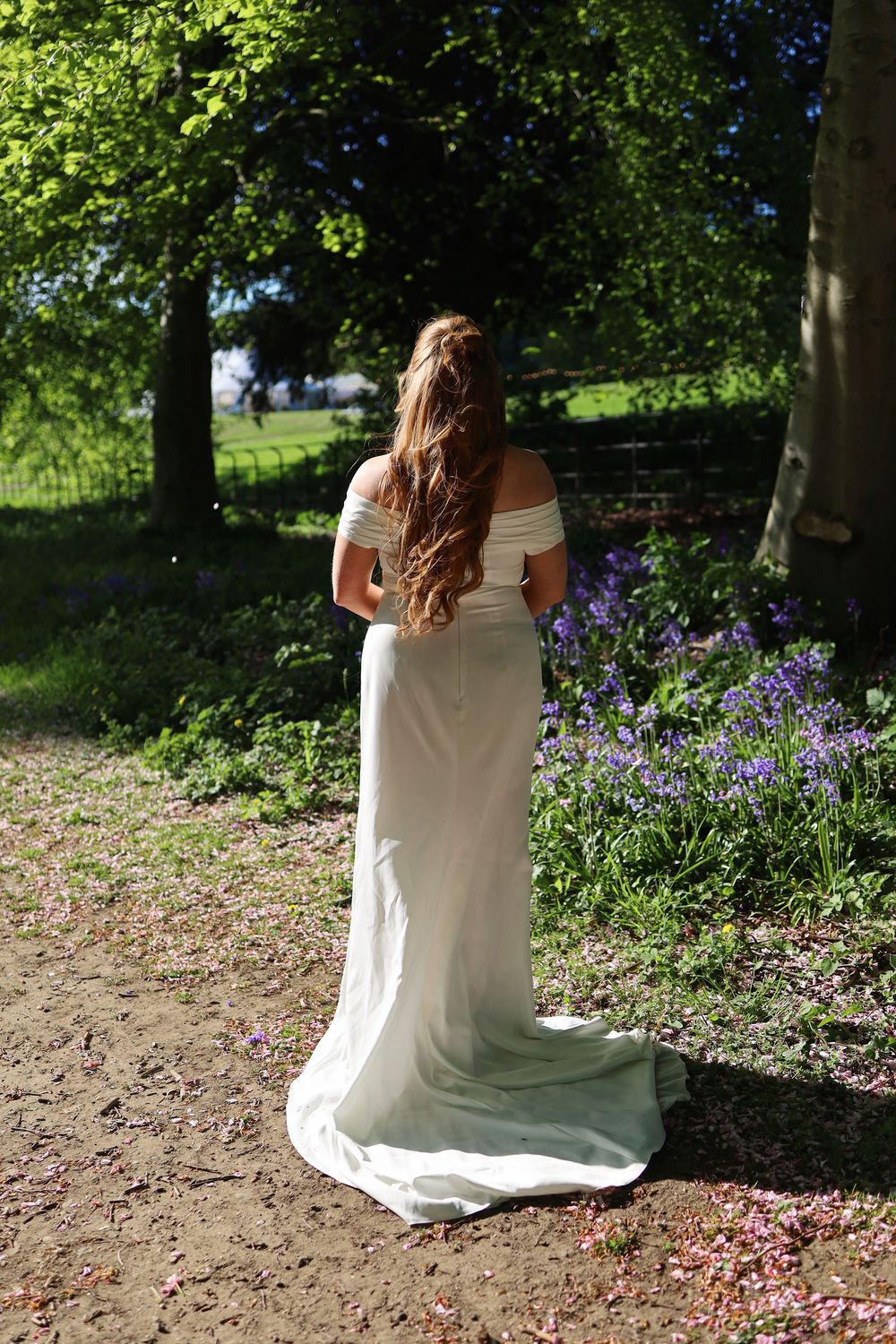 Outdoor bridal session among purple wildflowers and green foliage.