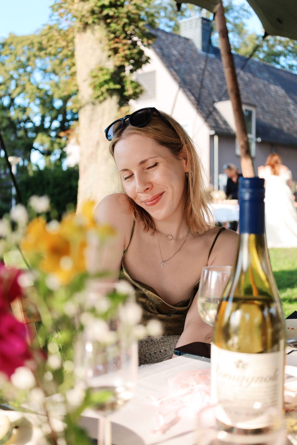 Casual outdoor dining scene with wine bottles and summer decor.