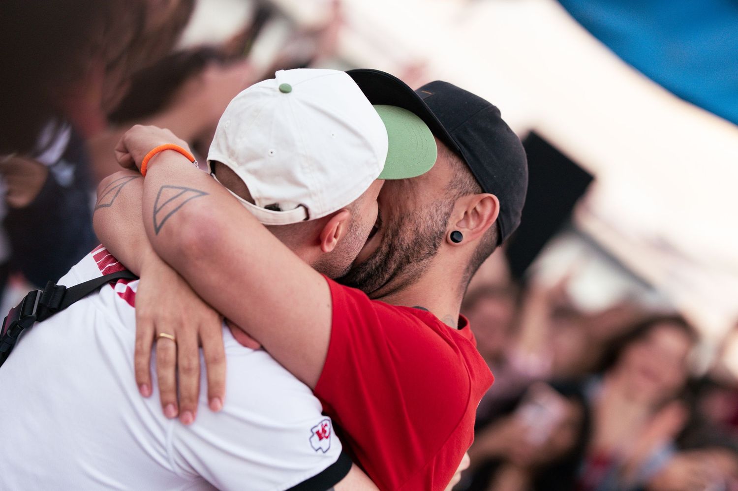Two sports fans embrace in celebration during an emotional moment at a game.