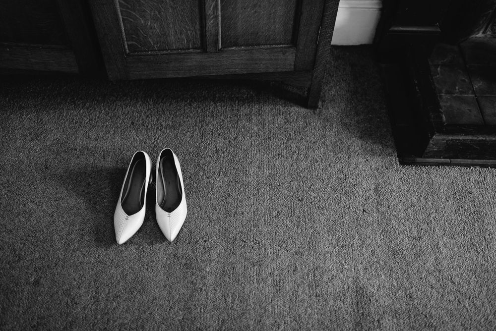 Collection of formal black and white shoes arranged on carpet.