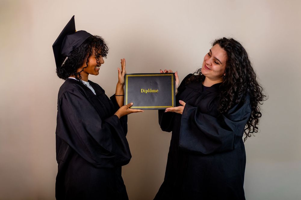 Copines qui ont reçu leur master et qui s'offrent une séance photo pour fêter leur diplôme