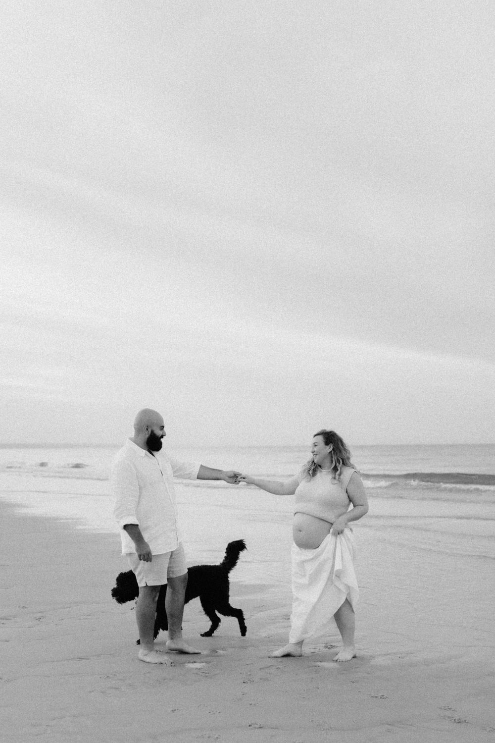 Lauren Lunn captures Adelaide couple and their dog enjoying a playful maternity session at sunrise on the beach.