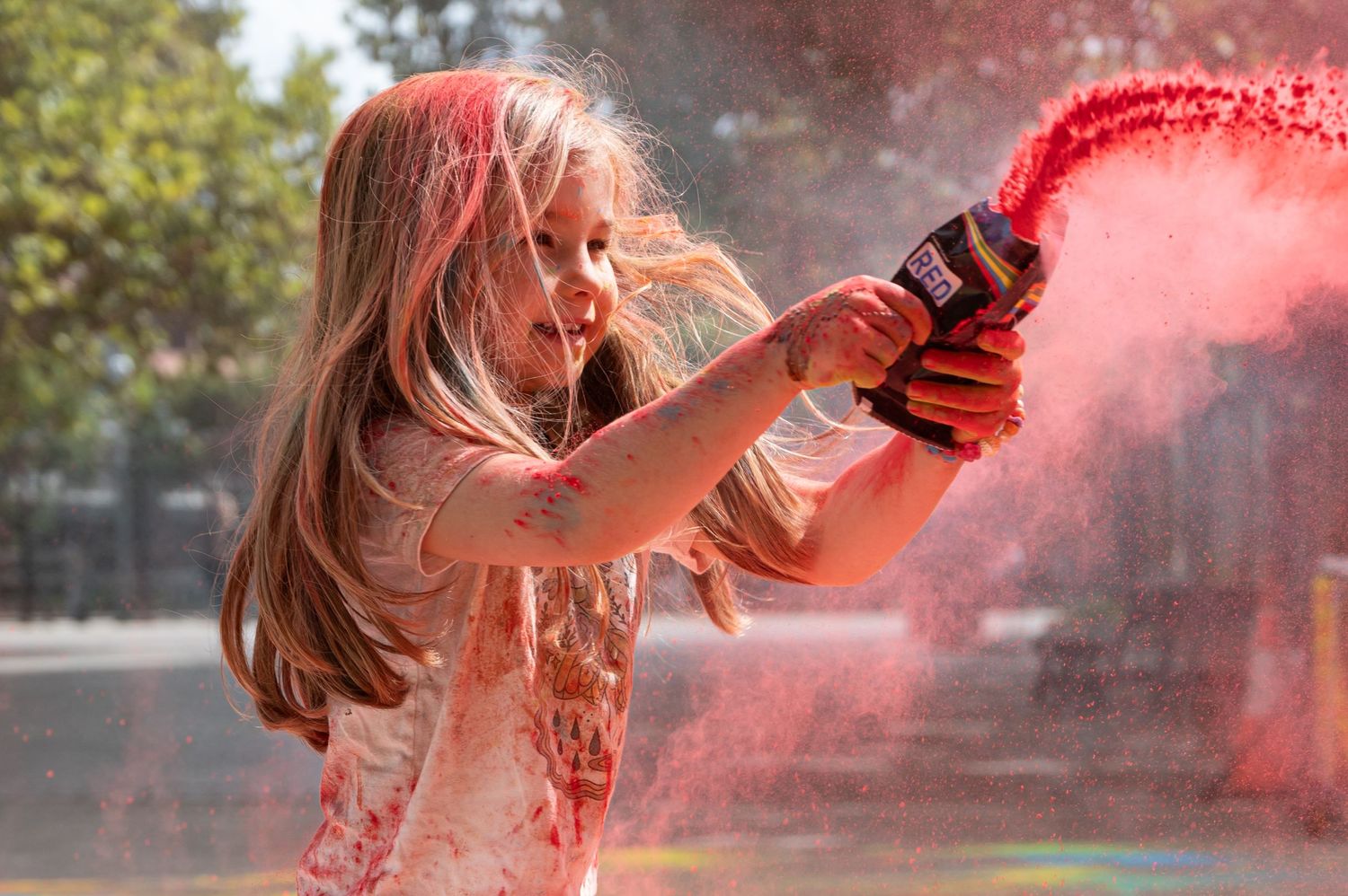 Young girl throwing paint at Holi Hai Festival in south Eveleigh, Sydney.