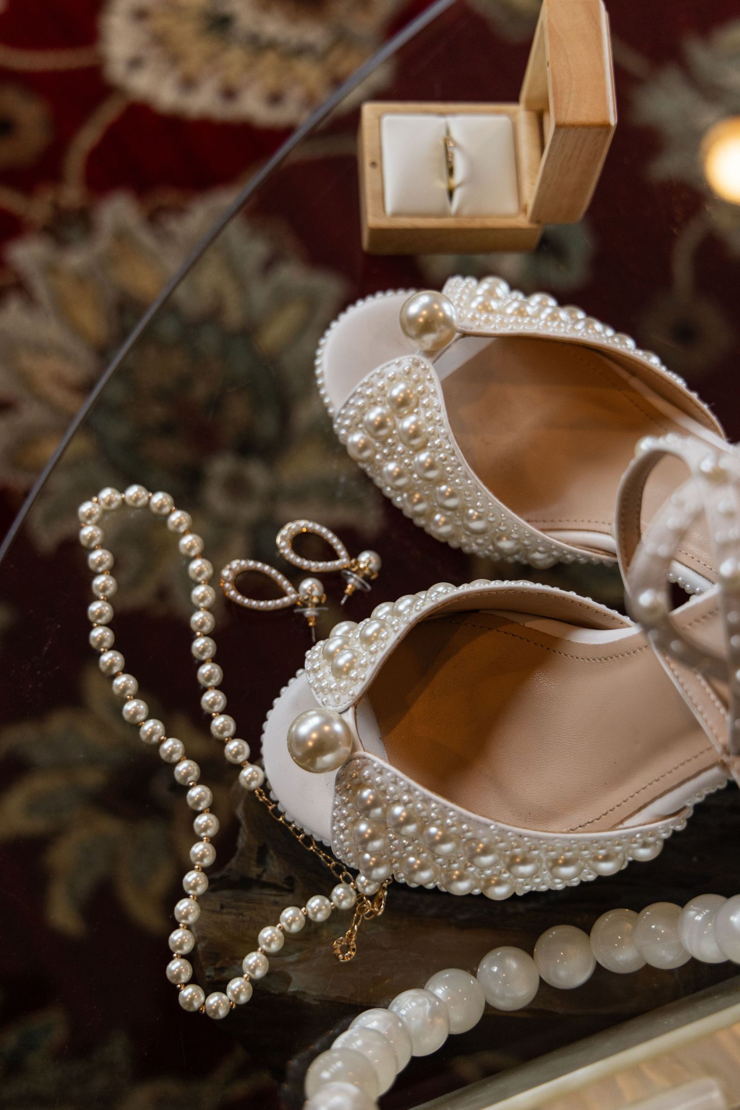 Elegant pearl and crystal wedding jewelry and accessories including necklaces and bridal shoes arranged on display.