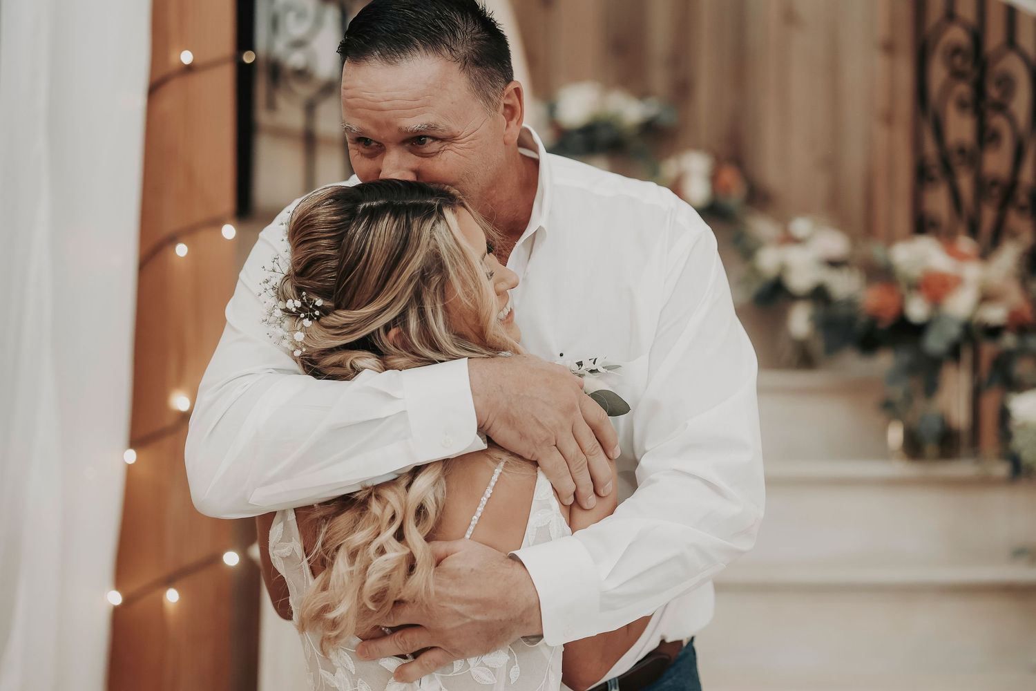 Father of the bride wiping away tears seeing daughter in wedding dress