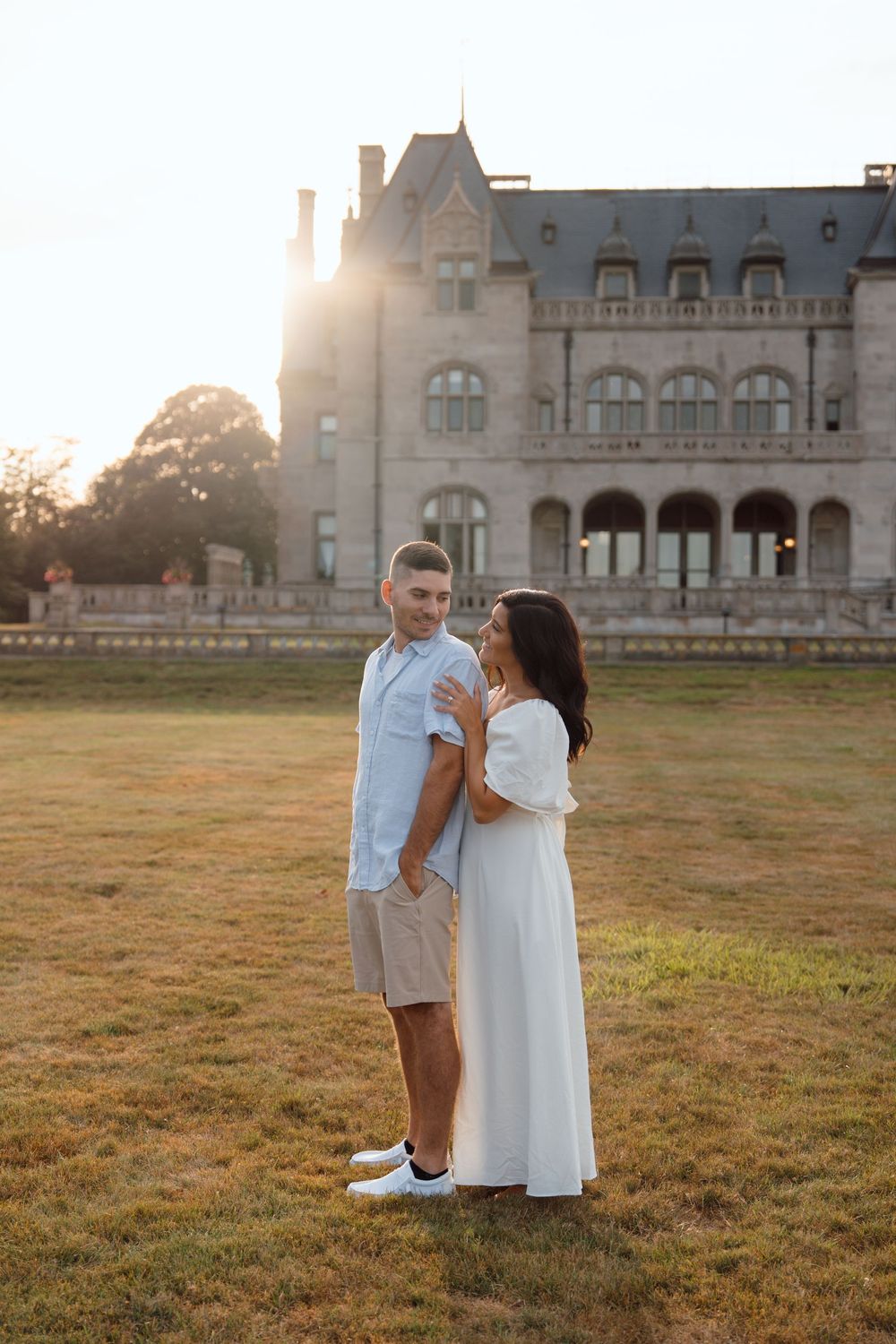 A romantic sunset portrait in front of a majestic historic mansion with golden light streaming through.