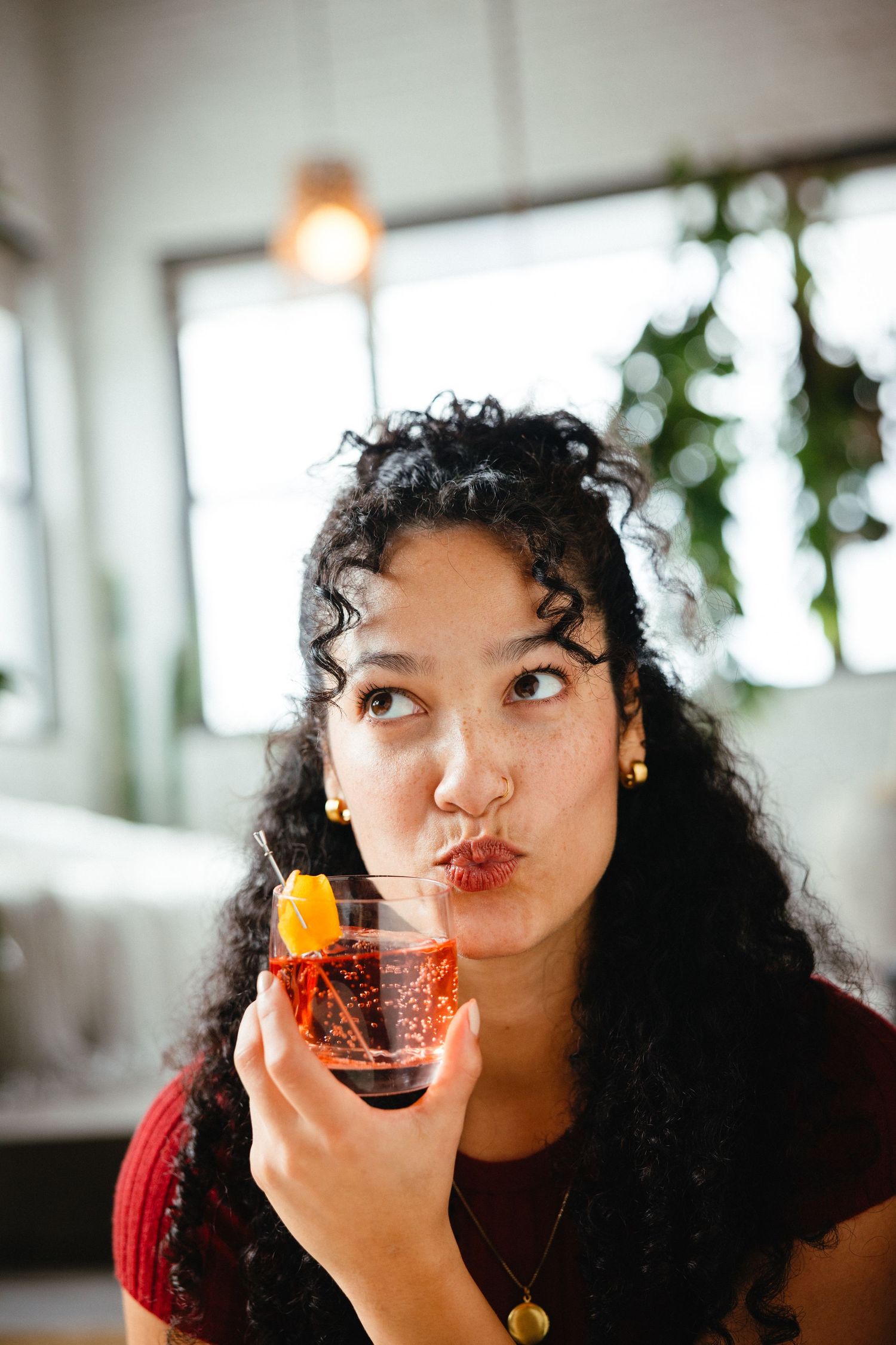 A sequence of photos shows someone drinking from a glass while making playful expressions in a bright indoor setting.
