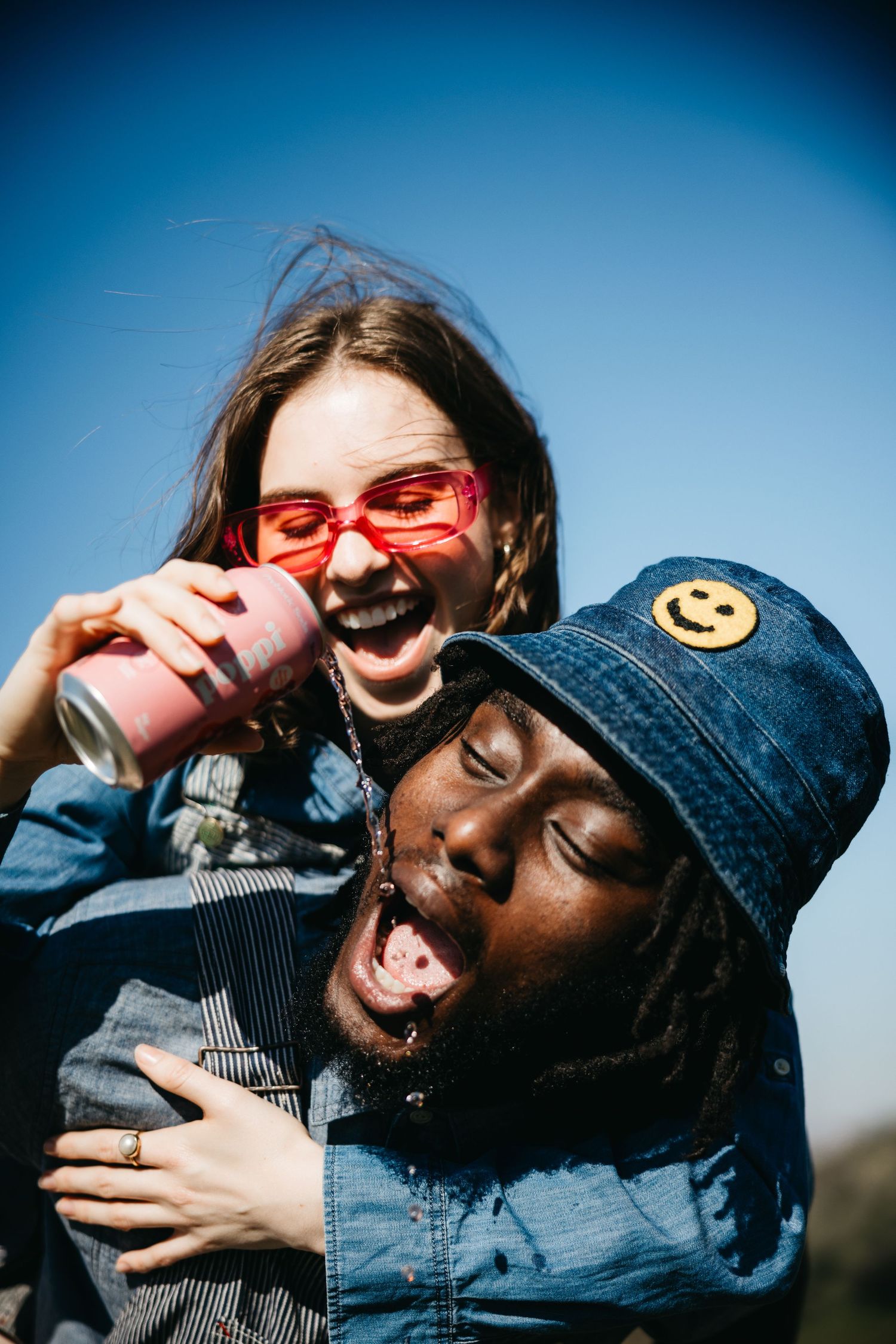 Candid shots of friends having fun and laughing together against a vivid blue sky.