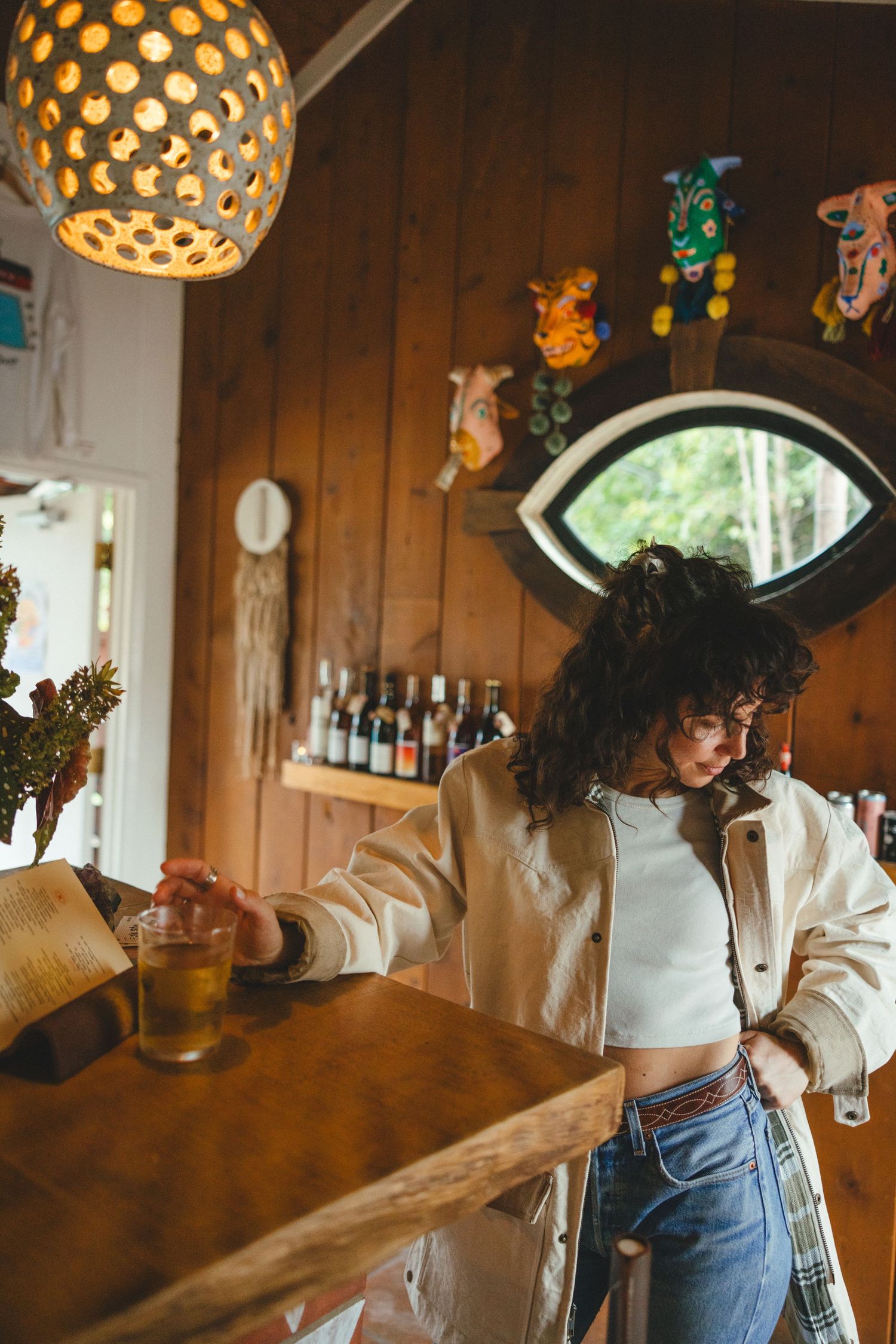 Interior scene with warm lighting featuring decorative spherical pendant lamps and wooden walls in a cozy bar setting.