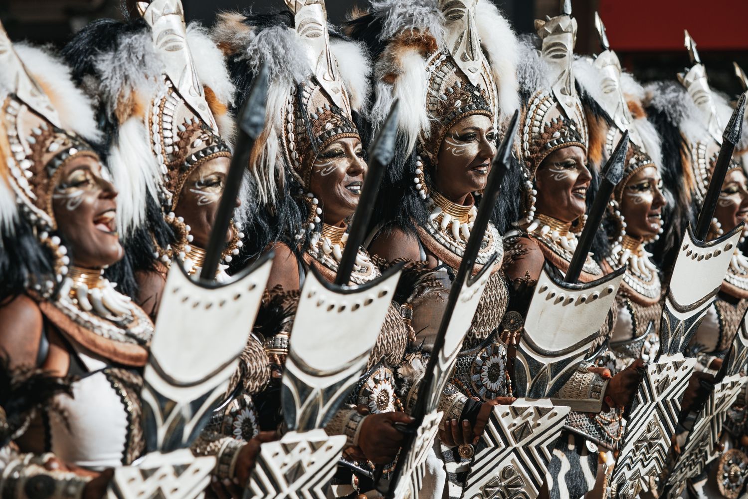 Crowd of performers in traditional African attire dancing and celebrating.