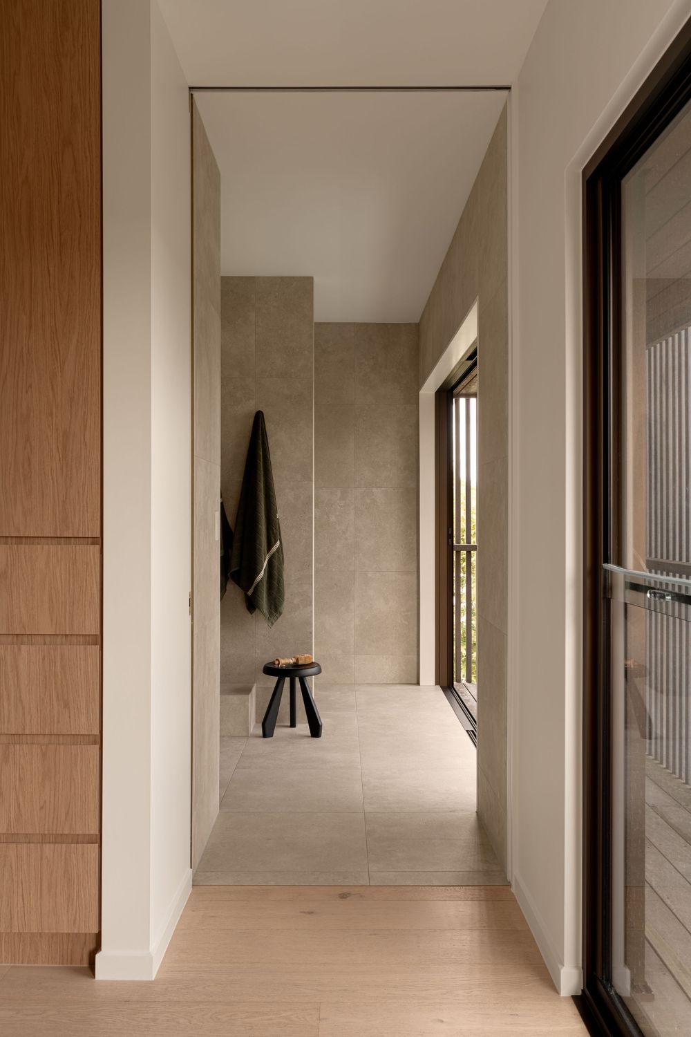 Minimalist modern hallway with wooden panels and white walls features clean lines and natural lighting.