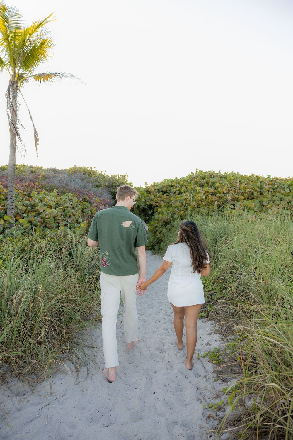 couple walking into mangroves after engagement at Hollywood North beach park