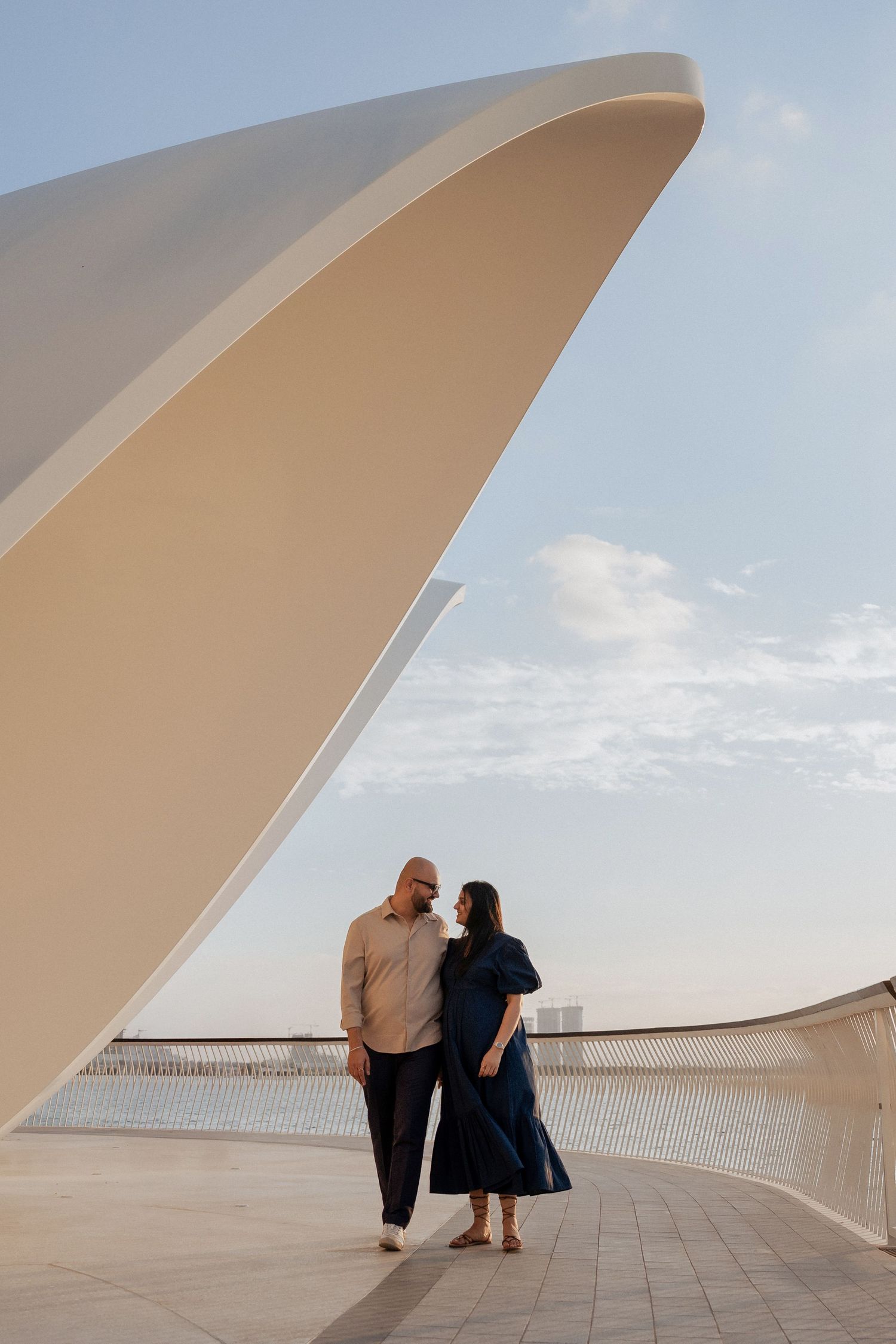 Couple standing near iconic modern architecture during destination photoshoot