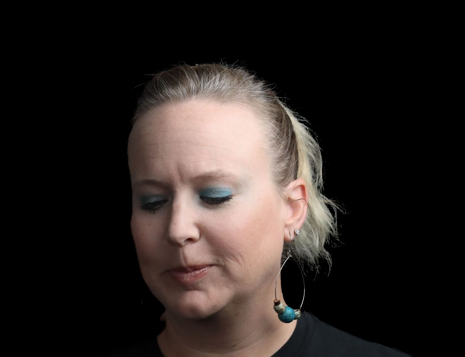 A series of close-up beauty shots showing dramatic blue eye makeup and blonde hair against a dark background.