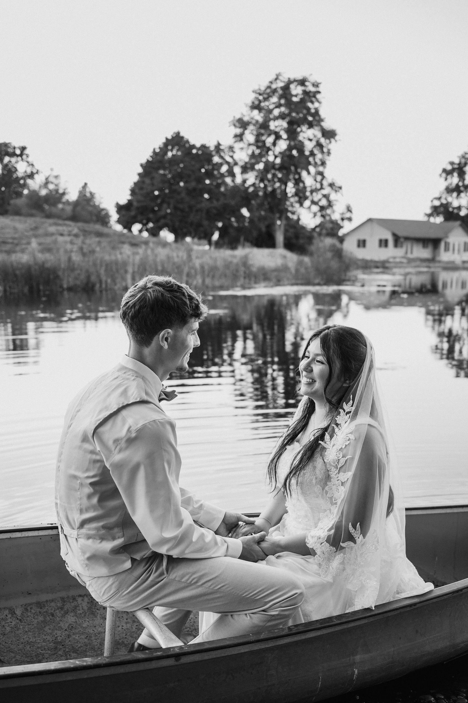 Sunset bride and groom portraits in a canoe on a pond