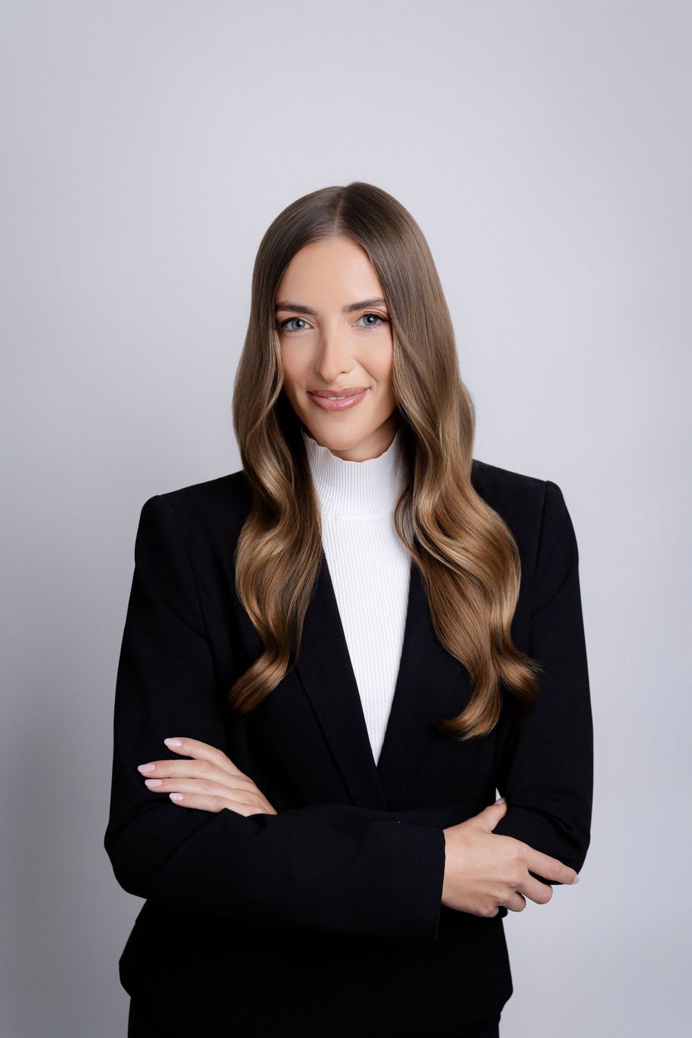 Business casual portraits featuring black blazer and white turtleneck in professional studio setting.