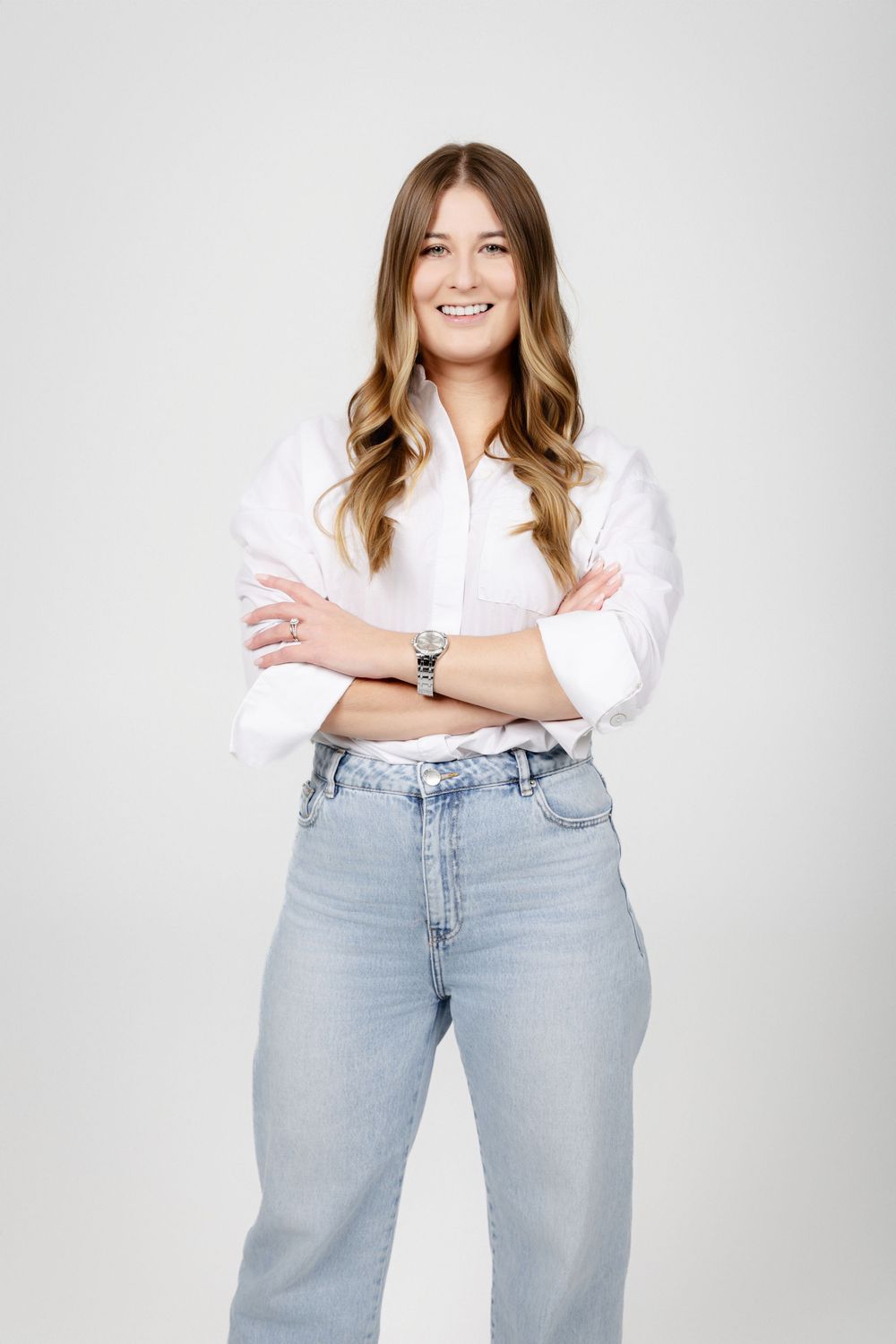 Professional studio portraits showing casual style with light denim jeans and white top against neutral background.