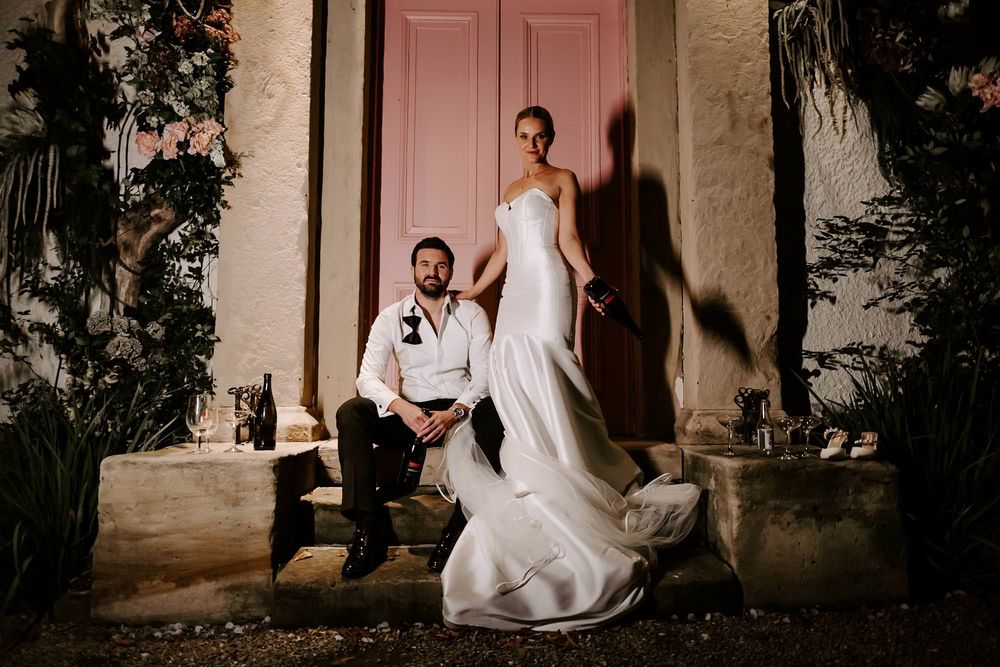 A romantic wedding photo series showing a couple in intimate poses against a rustic stone wall at dusk.