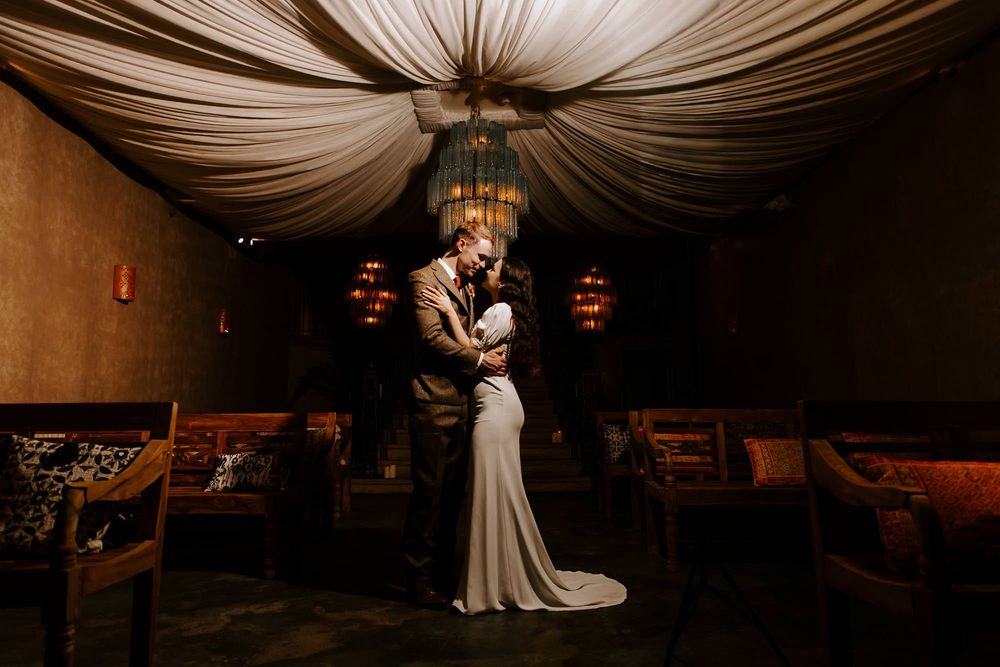 A wedding reception venue with draped white fabric ceiling and elegant lighting creating a romantic atmosphere.