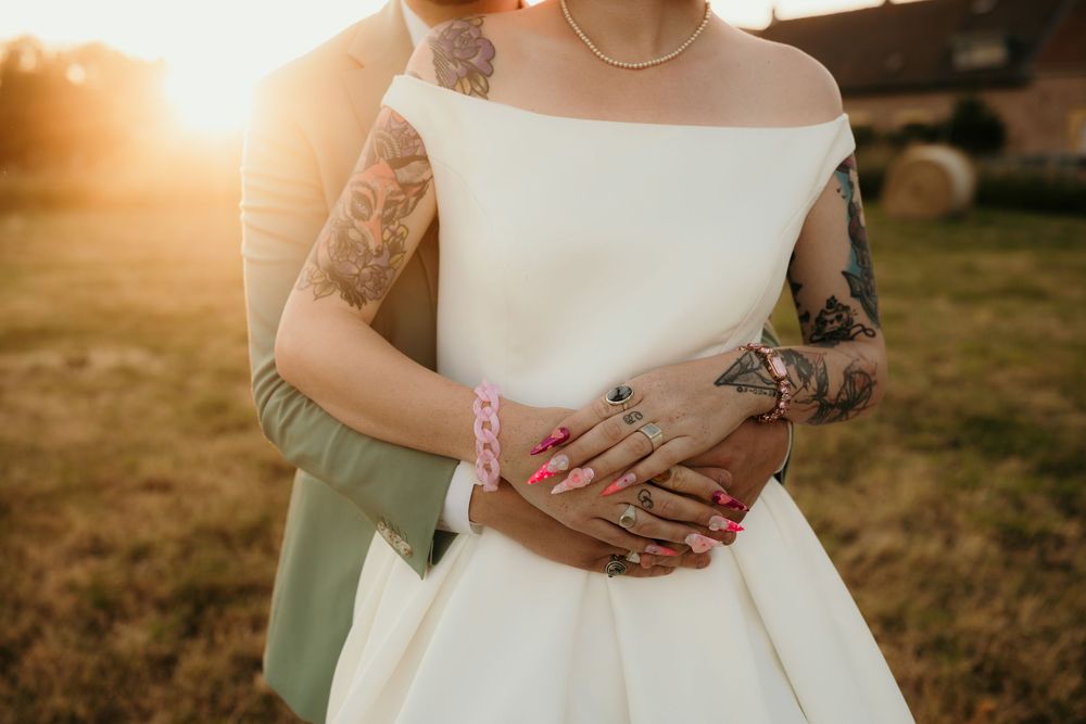 Close-up detail shots of hands wearing rings during golden hour wedding photography session.