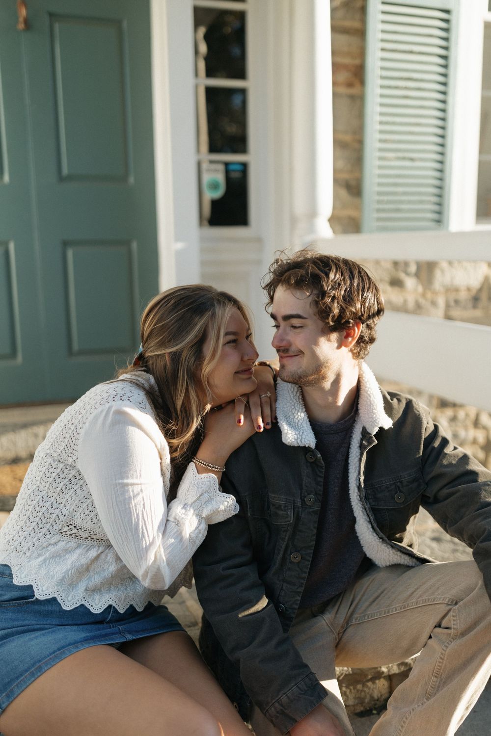 A couple shares intimate moments on a porch bench in a series of romantic photos.