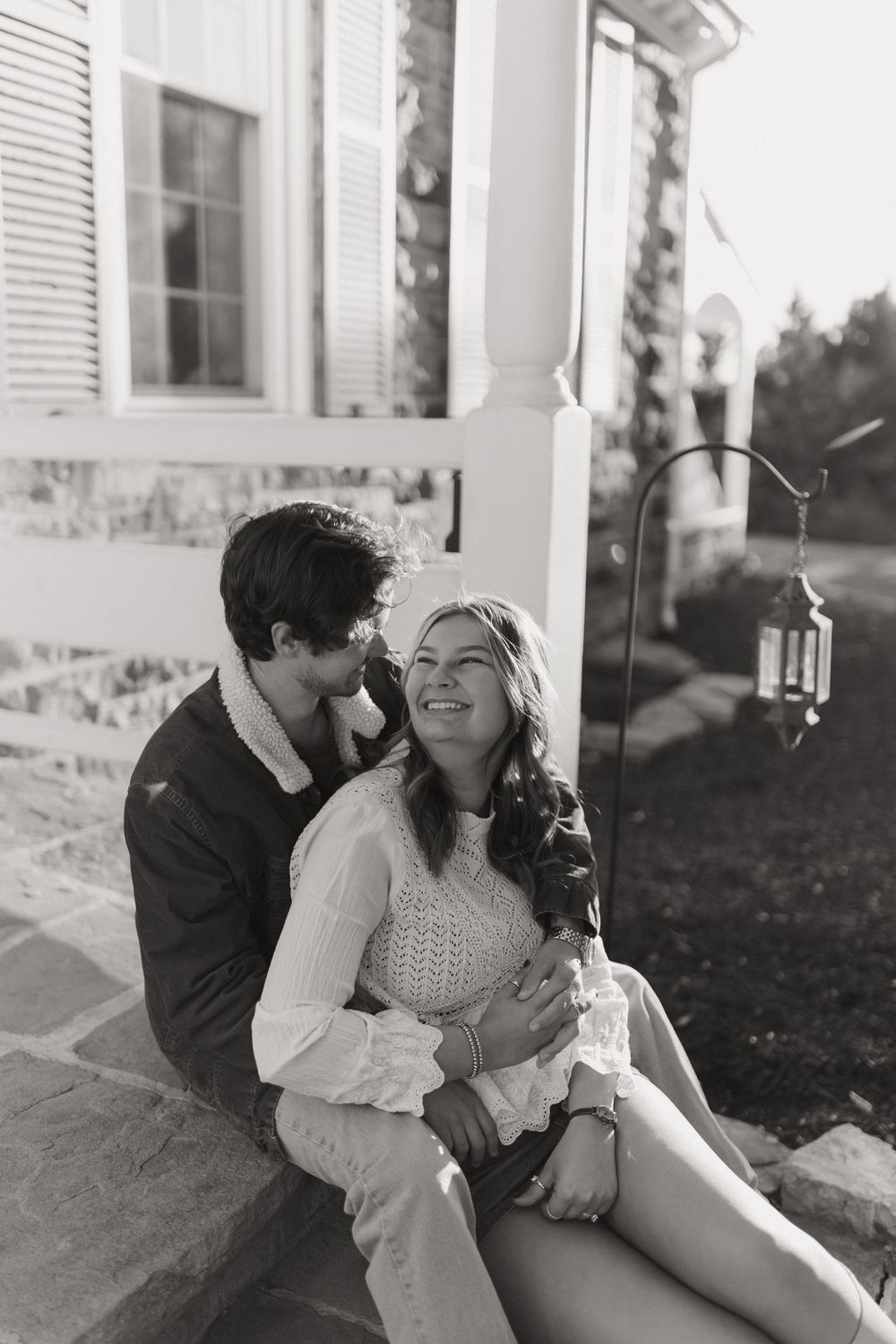 A romantic couple shares tender moments on a porch in a series of black and white photographs.