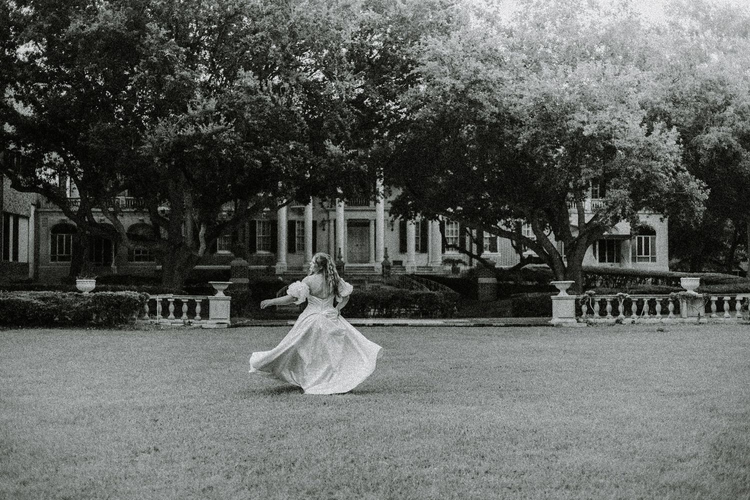 A black and white photo series showing a person in flowing white fabric moving gracefully through an empty room.