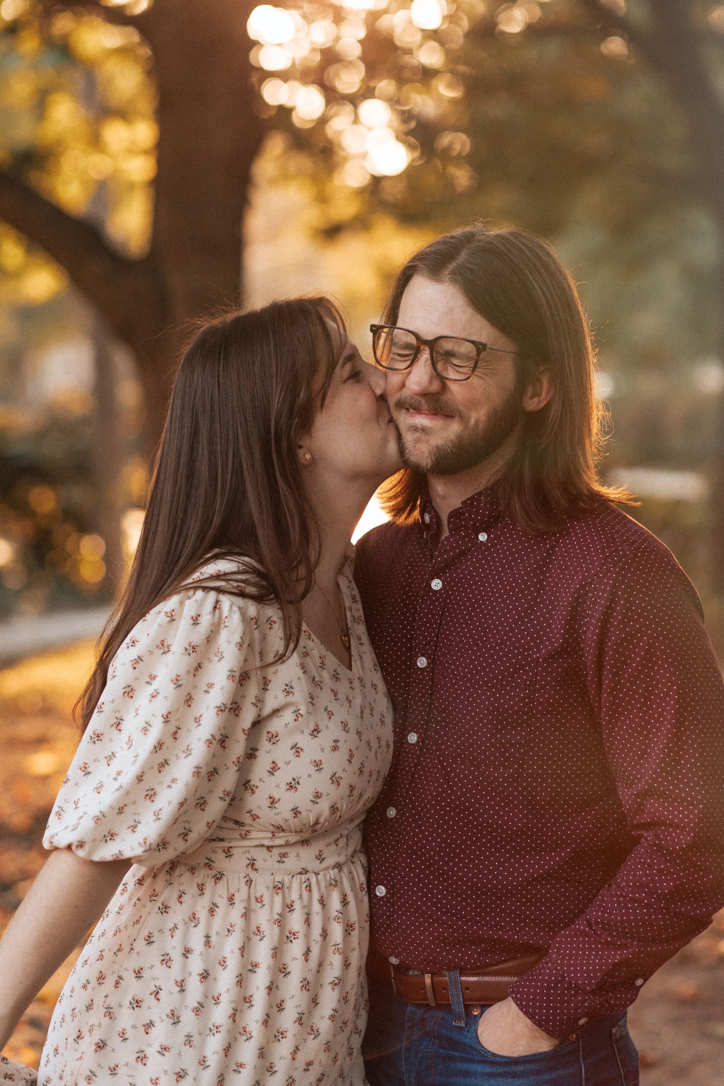 A couple shares intimate moments during a golden hour autumn photoshoot in the park.