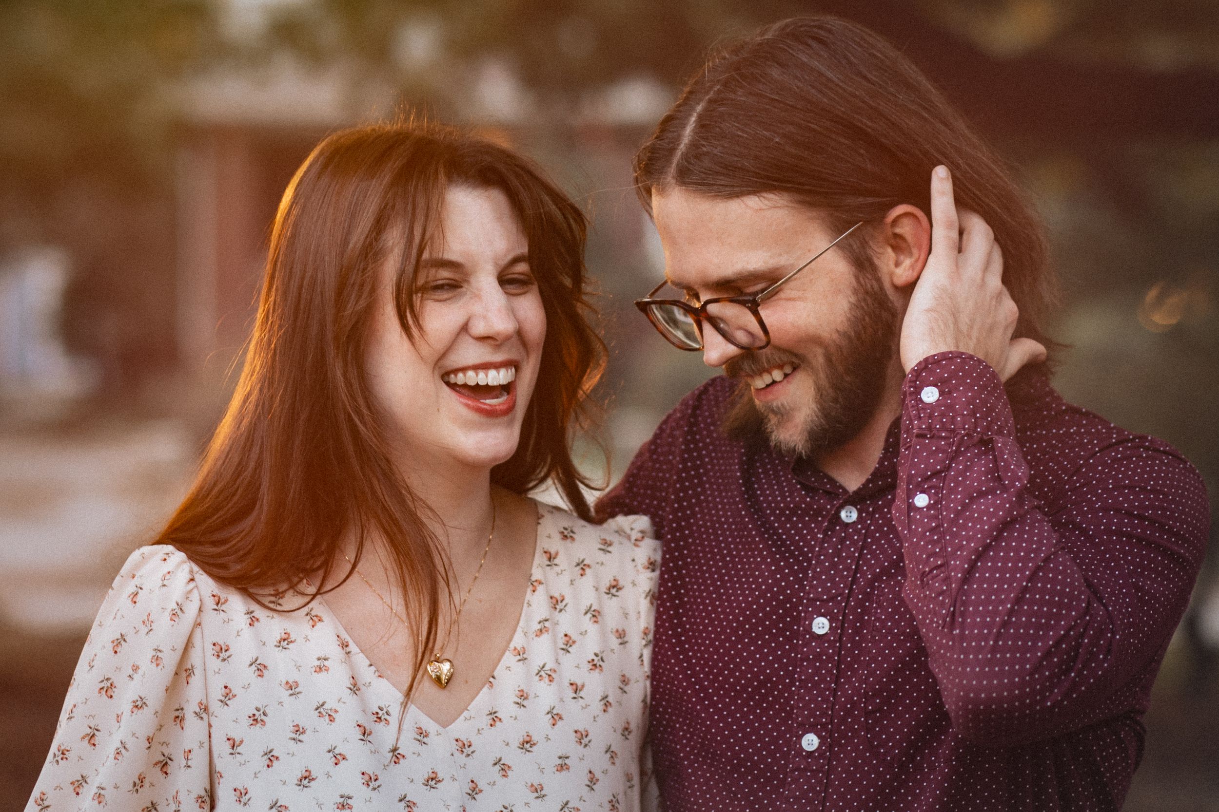 A couple shares intimate moments in a series of warm autumn-toned photographs outdoors.